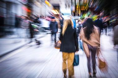 Two women pictured on busy blurred high street