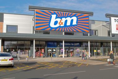 Exterior shot of B&M Stafford store showing car park and two customerrs