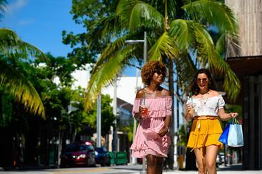 Friends carrying shopping bags on a sunny street