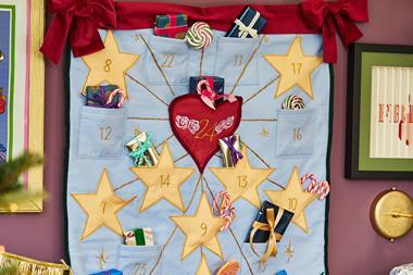 Notonthehighstreet's handmade felt-embroidered advent calendar, pictured with a child