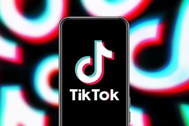 TikTok logo on a phone with TikTok logos in background