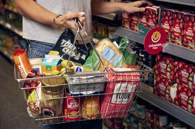 Customer carrying basket of groceries in Morrisons