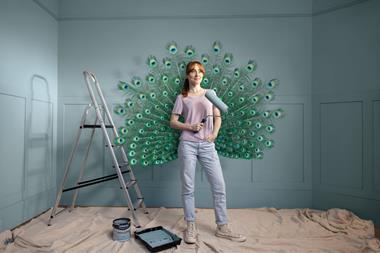 Woman holding a paint roller while decorating a room