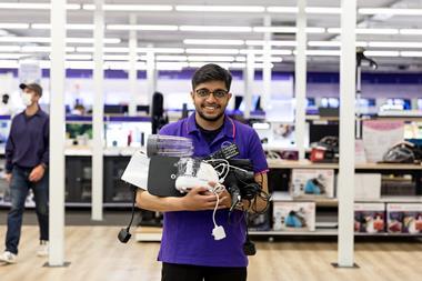 Currys employee with electronics for recycling