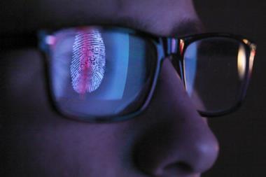 Cyber criminal in front of computer with biometrics