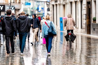 People walking down rainy shopping street