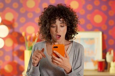 Female model in Temu advert looking at phone with expression of surprise