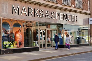Exterior of Marks & Spencer store in April 2021, with two face-mask wearing people walking past