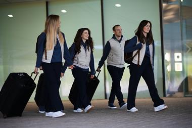 Models wearing Reiss x McLaren travel wear and carrying suitcases