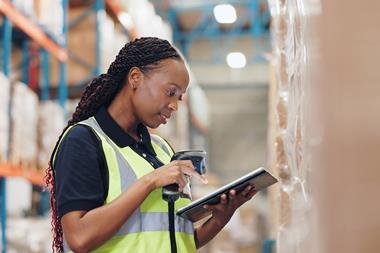 Warehouse worker using scanner and tablet