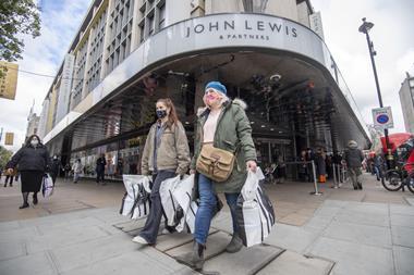 John Lewis Oxford Street with shoppers wearing Covid masks carrying shopping bags