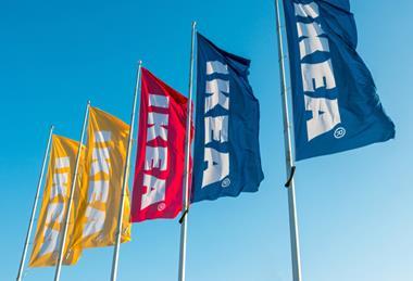 Five Ikea flags against a blue sky in yellow, red and blue