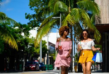 Friends carrying shopping bags on a sunny street