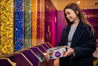 Woman selecting Quality Street chocolates at John Lewis Christmas shop
