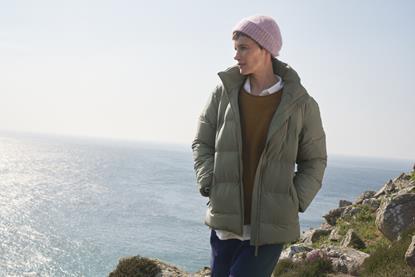 Female model wearing Seasalt clothing standing by sea