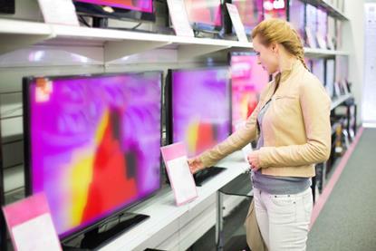 Woman looking at TVs in electrical shop