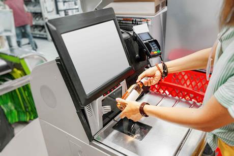 Woman scanning a wine bottle at self-checkout