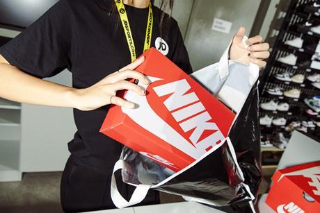 JD Sports worker putting Nike shoes in a bag