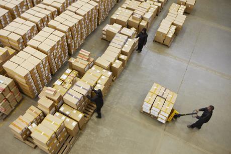 Workers moving boxes in a large warehouse