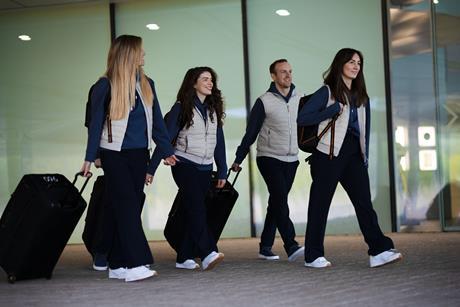 Models wearing Reiss x McLaren travel wear and carrying suitcases