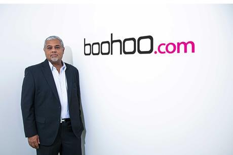 Mahmud Kamani in front of Boohoo logo