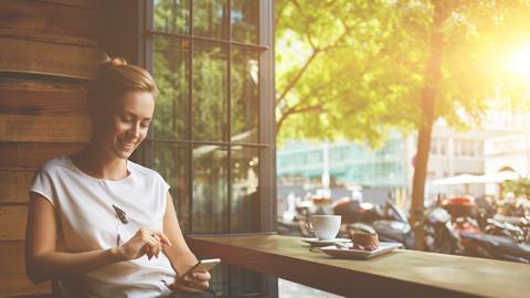 Woman on her phone at a coffee shop window