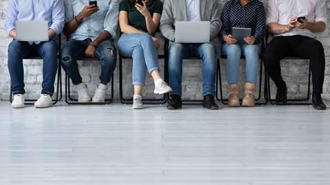 Six people queuing for job interview, seated, shown from head down