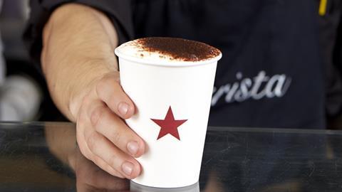 Pret coffee in a disposable cup being handed over the counter by a Pret barista