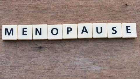 Scrabble letters spelling out 'Menopause' on a wooden background