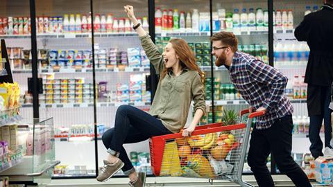 Man pushing woman on shopping trolley