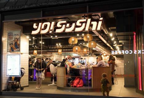 Exterior of Yo! Sushi store showing people eating inside