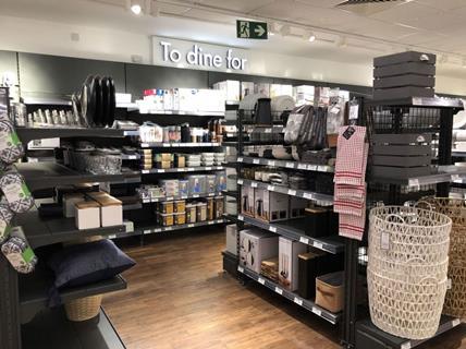 Interior of Dunelm store showing homeware with sign saying 'To dine for'