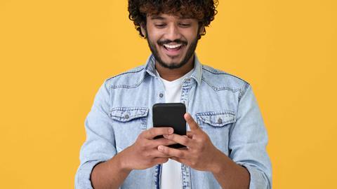 Young-man-looking-at-phone-and-smiling