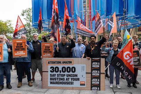 Amazon workers on strike at Coventry warehouse with GMB flags. Placard reads: 'Attention: Amazon: 30,000 say stop union busting at your warehouses!'