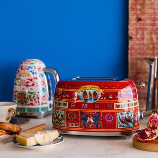 Promo photo showing products from the Smeg x Dolce & Gabbana collection including a kettle, a cup and a toaster