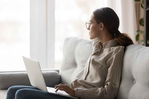 woman working from home with her laptop on a sofa