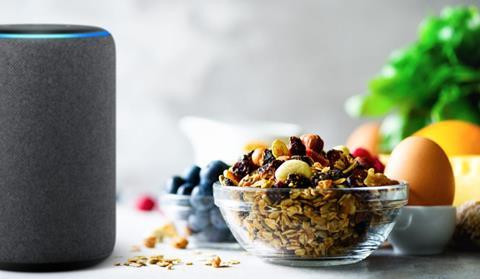Alexa device sat next to fruit, eggs and a bowl of granola in a kitchen