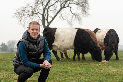John Pallagi in field with cows