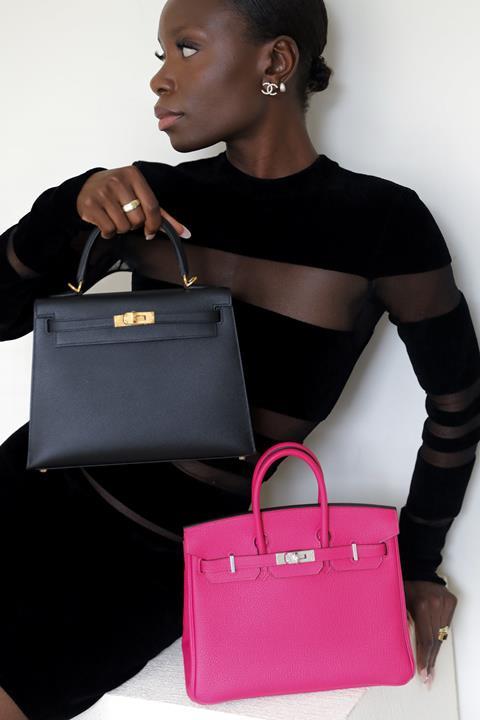 Model posing with designer hadnbags