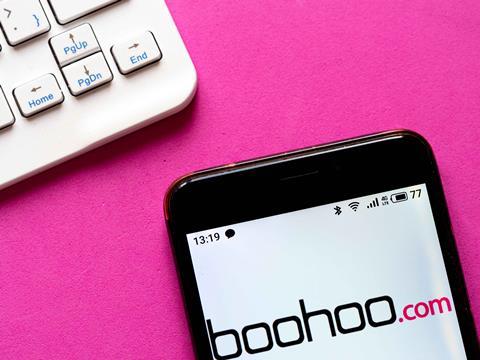 Boohoo site on smartphone next to keyboard