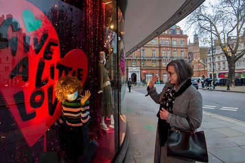 Woman looking into window of Peter Jones store in Chelsea