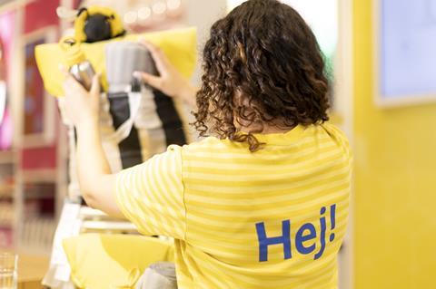 Woman in yellow Ikea uniform working in-store