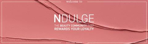 Screengrab from Space NK NDulge loyalty scheme on a background of pink make-up with the words: 'NDulge The beauty community that rewards your loyalty'