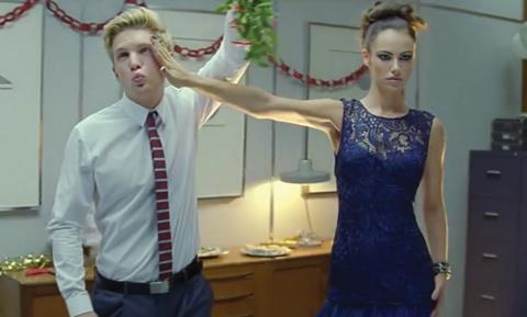 The ad shows festive scenarios such as an attempted Christmas party kiss
